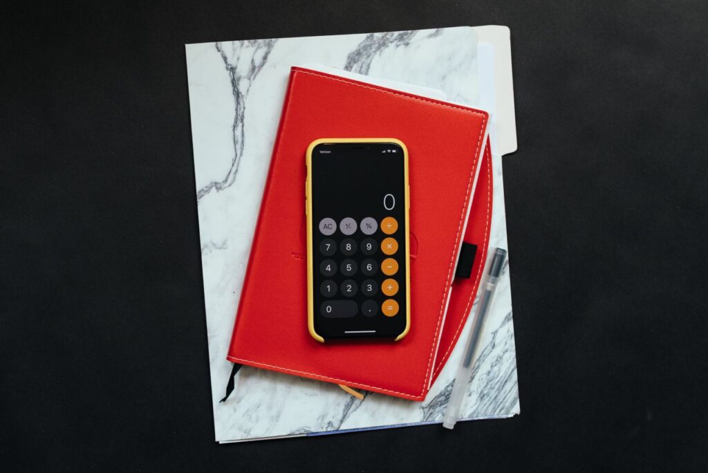 dossierm red notebook and phone calculator